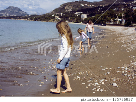 mother with twins daughters on beach lifestyle mother with twins daughters on beach lifestyle 125756937