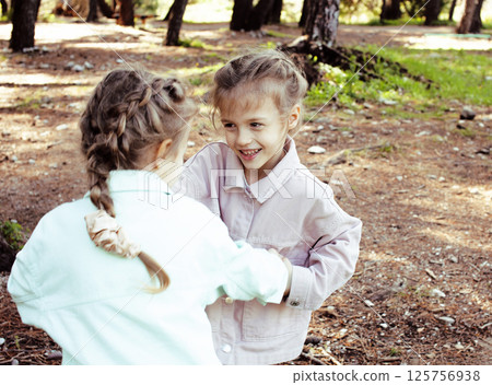 two pretty sisters twins playing outside, lifestyle people concept two pretty sisters twins playing outside, lifestyle people concept 125756938