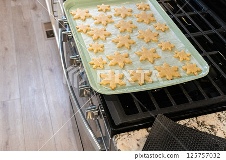 Letting delightful snowflake-shaped sugar cookies cool after baking, preparing them for festive Christmas gifts. Letting delightful snowflake-shaped sugar cookies cool after baking, preparing them for festive Christmas gifts. 125757032