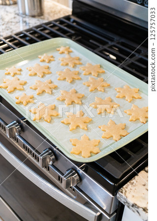 Letting delightful snowflake-shaped sugar cookies cool after baking, preparing them for festive Christmas gifts. Letting delightful snowflake-shaped sugar cookies cool after baking, preparing them for festive Christmas gifts. 125757033
