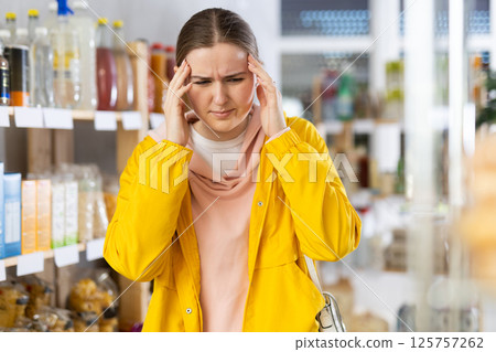 Young woman with headache in grocery store 125757262