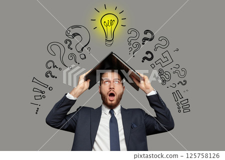 Emotional shocked businessman in suit with laptop on his head on grey background  125758126
