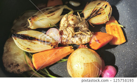Vegetables are fried in a frying pan for soup. Onions and carrots with celery 125758193
