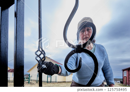 Ensuring durability of porch handrails, focused house painter applies corrosion-resistant coating, enjoying sense of accomplishment during work. Ensuring durability of porch handrails, focused house painter applies corrosion-resistant coating, enjoying sense of accomplishment during work. 125758495