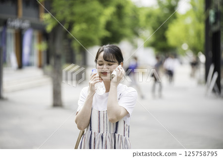 一名女子用瓶裝水冷卻脖子 125758795