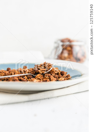Granola or baked oat flakes with chocolate and nuts. Healthy and simple breakfast. 125759140