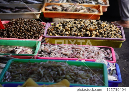 Fresh fish of various types displayed in blue plastic trays, likely at a market or fishmongers stall, ready for sale or cooking. Fresh fish of various types displayed in blue plastic trays, likely at a market or fishmongers stall, ready for sale or cooking. 125759404