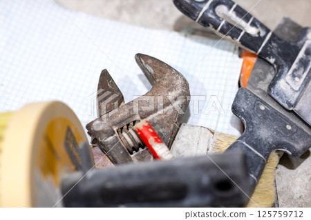A large wrench rests on graph paper, hinting at use or analysis 125759712