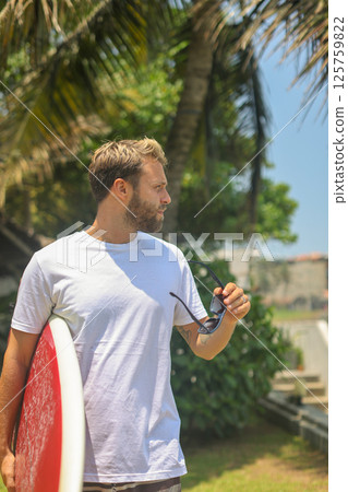 A Passionate Surfer Ready to Catch Exciting Waves in a Beautiful Tropical Paradise A Passionate Surfer Ready to Catch Exciting Waves in a Beautiful Tropical Paradise 125759822