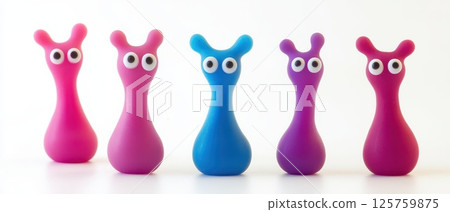 Brightly colored toy figures lined up on a surface 125759875