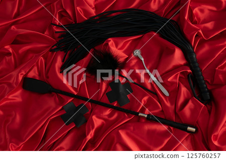 Adult sex games. Kinky lifestyle. Spank and whip ridding crop on the red linen. Bdsm outfit Adult sex games. Kinky lifestyle. Spank and whip ridding crop on the red linen. Bdsm outfit 125760257