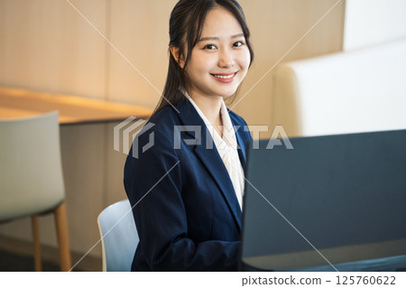 A young career woman in her 20s working at a desk in an office 125760622