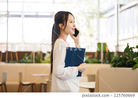 A career woman talking on a smartphone in a stylish office 125760669