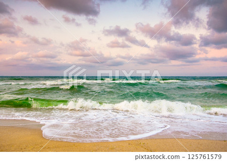 cloudy evening sky at the black sea. rolling waves. weather change in nature. beautiful orange cloudscape. dramatic summer vacation in europe at the beach 125761579