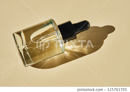 Oily serum with peptides on a beige background. Oily serum with peptides on a beige background. 125761705