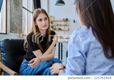 Young woman talking to social worker, home visit of psychological counselor Young woman talking to social worker, home visit of psychological counselor 125761929