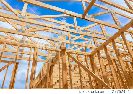 Worker are building wooden trusses frame structure with beams trusses under construction area 125762465
