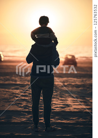 silhouette of mother with toddler on shoulders at beach during sunset 125763532