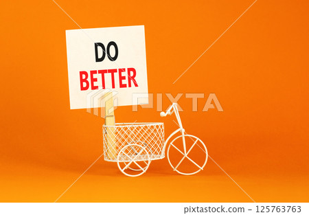 Do better symbol. Concept words Do better on beautiful white paper on wooden clothespin. Beautiful orange background. Bicycle. Business and do better concept. Copy space. Do better symbol. Concept words Do better on beautiful white paper on wooden clothespin. Beautiful orange background. Bicycle. Business and do better concept. Copy space. 125763763