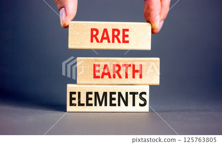 Rare earth elements symbol. Concept words Rare earth elements on beautiful wooden block. Businessman's hand. Beautiful grey background. Business and rare earth elements concept. Copy space. 125763805