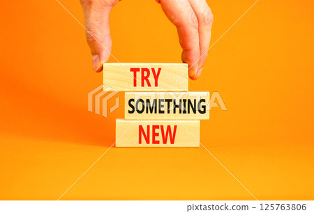Try something new symbol. Concept words Try something new on beautiful block. Businessman's hand. Beautiful orange background. Business motivational lifestyle try something new concept. Copy space. Try something new symbol. Concept words Try something new on beautiful block. Businessman's hand. Beautiful orange background. Business motivational lifestyle try something new concept. Copy space. 125763806