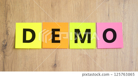 Demo symbol. Concept word Demo on beautiful colored paper. Beautiful wooden table wooden background. Business and demo concept. Copy space. 125763865