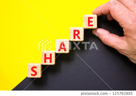 Share symbol. Concept word Share on beautiful wooden blocks. Beautiful yellow and black background. Businessman hand. Business lifestyle share concept. Copy space. 125763885