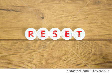Reset symbol. Concept word Reset on beautiful white pills circles. Beautiful wooden table wooden background. Business lifestyle reset concept. Copy space. 125763893