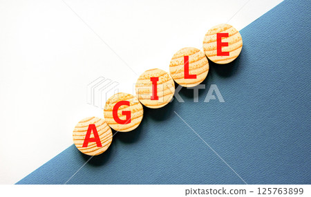 Agile symbol. Concept word Agile on beautiful wooden circles. Beautiful white and blue background. Business flexible and agile concept. Copy space. 125763899