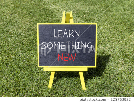 Learn something new symbol. Concept words Learn something new on beautiful yellow blackboard. Beautiful green grass background. Business motivational lifestyle learn something new concept. Copy space. 125763922