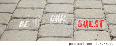 Be our guest symbol. Concept words Be our guest on beautiful grey road break. Beautiful grey road break background. Business and be our guest concept. Copy space. 125763949