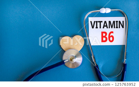 Vitamin B6 symbol. Concept words Vitamin B6 on beautiful white card. Wooden heart and stethoscope. Beautiful blue background. Medical healthy lifestyle Vitamin B6 concept. Vitamin B6 symbol. Concept words Vitamin B6 on beautiful white card. Wooden heart and stethoscope. Beautiful blue background. Medical healthy lifestyle Vitamin B6 concept. 125763952
