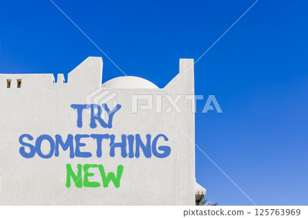 Try something new symbol. Concept words Try something new on beautiful white wall. Beautiful white wall blue sky background. Business motivational lifestyle try something new concept. Copy space. Try something new symbol. Concept words Try something new on beautiful white wall. Beautiful white wall blue sky background. Business motivational lifestyle try something new concept. Copy space. 125763969