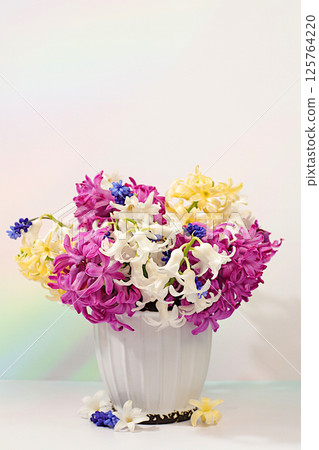 Abstract flower arrangement. Beautiful banner of different varieties of hyacinths and muscari in a vase, template for design and screen. Spring card, business card for product display, 125764220