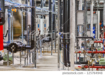 Detailed Interior View of a Complex Industrial Piping and Plumbing System within a Manufacturing Facility 125764948