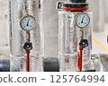 Two Industrial Pressure Gauges with Metal Housings and Insulation Displaying Measurements in Bar  125764994