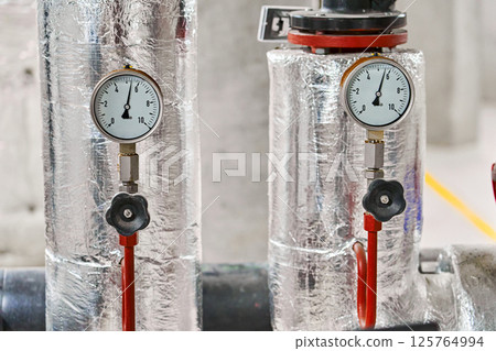 Two Industrial Pressure Gauges with Metal Housings and Insulation Displaying Measurements in Bar  125764994