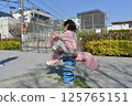 Girls playing with park play equipment 125765151