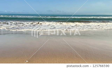 Experience the serene beach waves at sunset, creating a blissful moment of peace and tranquility 125766590