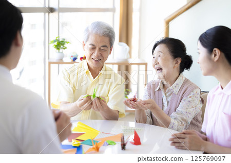 Care image: Seniors and caregivers folding origami Care image: Seniors and caregivers folding origami 125769097