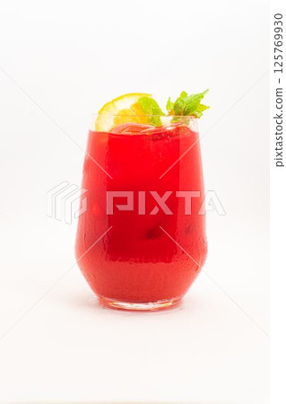 vibrant red berry cocktail with orange slice and fresh mint leaves served in clear glass with ice on white background. High quality photo 125769930