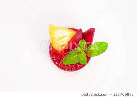 red beet or berry smoothie with pineapple slice and mint garnish served in transparent glass on white background. High quality photo red beet or berry smoothie with pineapple slice and mint garnish served in transparent glass on white background. High quality photo 125769932