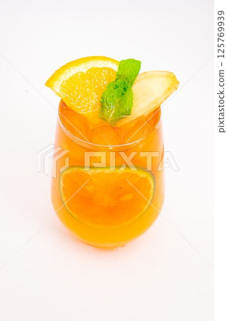 refreshing orange citrus cocktail with sliced lemon and mint leaves served in clear glass over ice on white background. High quality photo refreshing orange citrus cocktail with sliced lemon and mint leaves served in clear glass over ice on white background. High quality photo 125769939