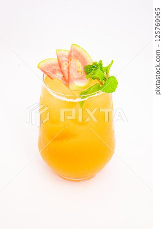 orange peach cocktail with strawberry slices and fresh mint served in transparent glass over ice on white background. High quality photo 125769965