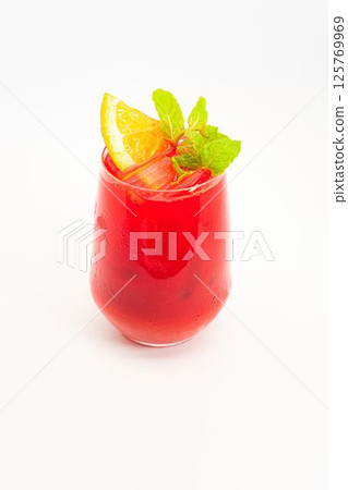 vibrant red berry cocktail with orange slice and fresh mint leaves served in clear glass with ice on white background. High quality photo 125769969