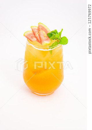 orange peach cocktail with strawberry slices and fresh mint served in transparent glass over ice on white background. High quality photo 125769972