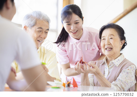 護理形象：老年人和照顧者折疊摺紙 125770032