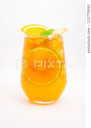 refreshing orange citrus cocktail with sliced lemon and mint leaves served in clear glass over ice on white background. High quality photo 125770091