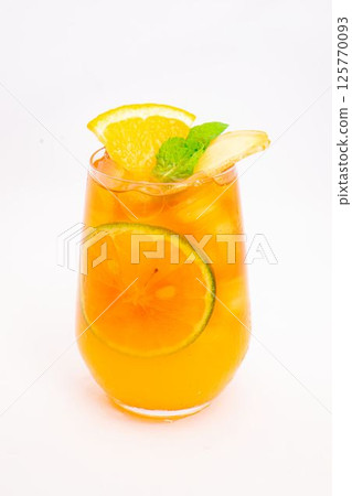 refreshing orange citrus cocktail with sliced lemon and mint leaves served in clear glass over ice on white background. High quality photo 125770093