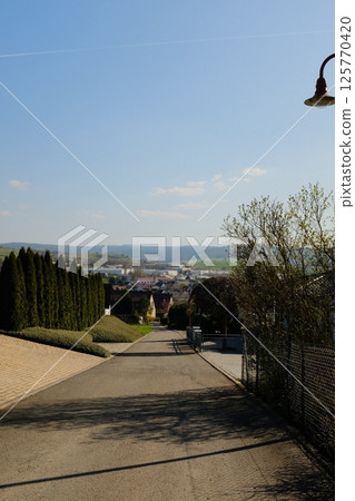 wide open green countryside field under clear blue sky with distant trees and rolling hills in peaceful rural landscape. High quality photo wide open green countryside field under clear blue sky with distant trees and rolling hills in peaceful rural landscape. High quality photo 125770420